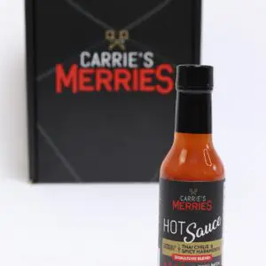 Hot sauce bottle with branded packaging behind.